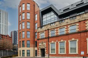 a red brick building with a statue on it at Luxury Serviced Penthouse - City Centre - En Suite Bedrooms - Free Netflix in Leeds