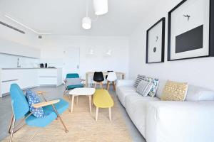 ein Wohnzimmer mit einem weißen Sofa und Stühlen in der Unterkunft Yellow blue by HolyGuest in Tel Aviv