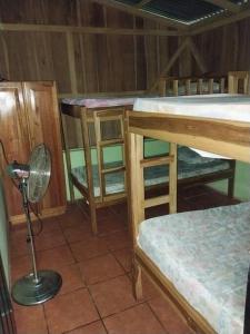 a room with three bunk beds and a fan at Quinta Elisyum, con Piscina y Rancho in San Ramón