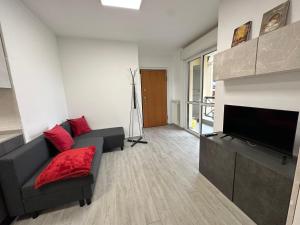 ein Wohnzimmer mit einem Sofa und einem Flachbild-TV in der Unterkunft Deluxe comfortable suite with balcony Downtown in Castellanza