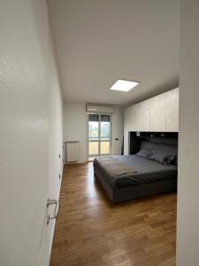 um quarto com uma cama e piso em madeira em Deluxe comfortable suite with balcony Downtown em Castellanza