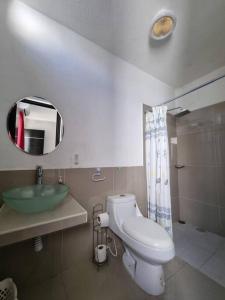 a bathroom with a toilet and a sink and a mirror at Melaque Rent House 1 in San Patricio Melaque