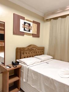 ItaitubaにあるHotel Camposのベッド2台と鏡が備わるホテルルームです。