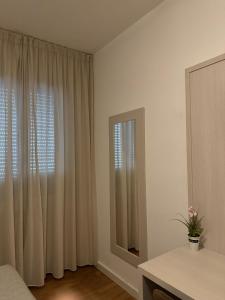 a bedroom with a bed and a window with curtains at Hotel La Pace in Pontedera