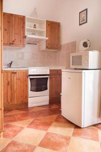 a kitchen with white appliances and wooden cabinets at Penzion Planiska in Frenštát pod Radhoštěm