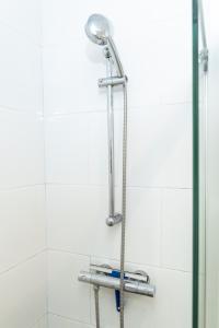 a shower with a shower head in a bathroom at SurfersResidence Apartments in Tarifa +26 photos