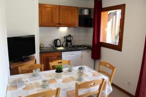 a kitchen with a table and chairs and a kitchen with a table and a table at Les Chalets De Superd Gentiane - 2 Pièces pour 6 Personnes MAE-9124 in Le Dévoluy