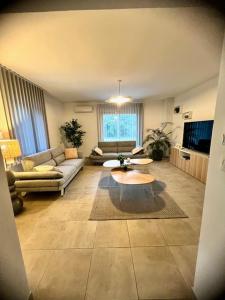 ein Wohnzimmer mit einem Sofa und einem Tisch in der Unterkunft Les jardins de funtanone T4 in Vignale