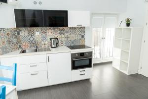 a white kitchen with a sink and a stove at SurfersResidence Apartments in Tarifa