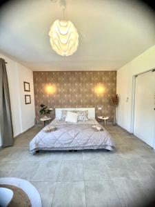 Schlafzimmer mit einem Bett und einem Kronleuchter in der Unterkunft Les jardins de funtanone T4 in Vignale