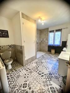 a bathroom with a toilet and a tiled floor at Les jardins de funtanone T4 in Vignale