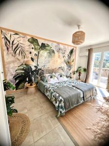 Schlafzimmer mit einem Bett mit Wandgemälde in der Unterkunft Les jardins de funtanone T4 in Vignale