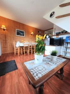 a living room with a table and a kitchen at Résidence Le Hameau Du Puy - Chalets pour 6 Personnes 874 in Le Dévoluy