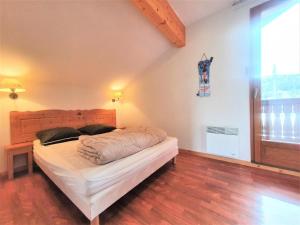 a bedroom with a bed with a wooden head board at Résidence Le Hameau Du Puy - Chalets pour 6 Personnes 874 in Le Dévoluy