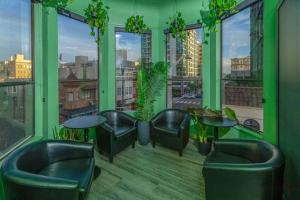 a green room with chairs and tables and windows at Chapter San Francisco in San Francisco