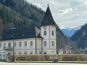 un gran edificio blanco con una torre de reloj en Mountain Adventure Base - Vienna Alps, en Graben
