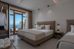 a hotel room with two beds and a balcony at Alia Palace Hotel - Adults Only 16+ in Pefkohori
