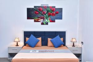 1 dormitorio con 1 cama con flores rojas en un jarrón en Victoria Hideout en Digana