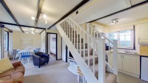 sala de estar con escalera blanca y cocina en 33 Tudor Court, en Hayle