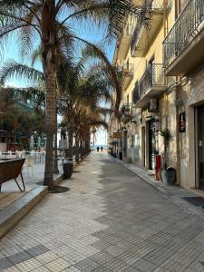 pusta ulica z palmami i budynkami w obiekcie Casa Macallè - Letojanni - Taormina w mieście Letojanni