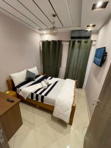 1 dormitorio con 1 cama con cortina verde en Résidence les Jardin d Anass Aéroport Marrakech en Marrakech