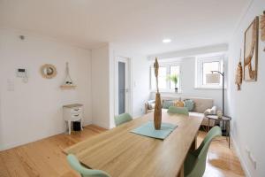 - une salle à manger et un salon avec une table et des chaises en bois dans l'établissement Cozy Bohemian Flat - Mint, à Lisbonne