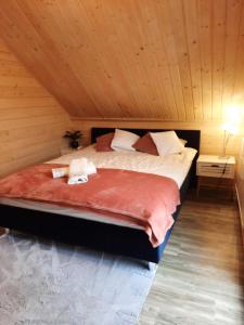 een slaapkamer met een groot bed in een houten plafond bij Domek Ostoja in Łomnica