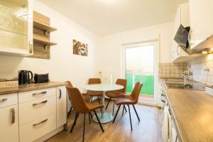 a kitchen with a table and chairs in a room at Homefeeling Apartment am Eisweiher Park in Pirmasens