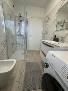 een badkamer met een douche, een wastafel en een toilet bij Deluxe Comfortable suite with balconie in Castellanza