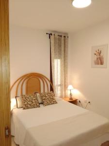 a bedroom with a white bed and a window at La Calma in Lliber
