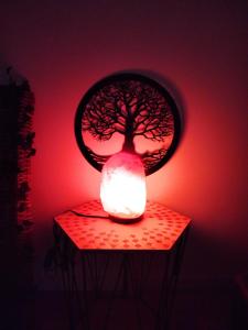 eine Lampe mit einem Baum auf einem Tisch in der Unterkunft Maison Prestige Le Donjon des Plaisirs Jacuzzi in Montluel