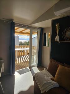 ein Wohnzimmer mit einer Glasschiebetür zur Terrasse in der Unterkunft Casa Luisa Mobil Home in Canet-en-Roussillon