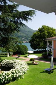 a park with white flowers and a body of water at Apt. 123 - Beautiful apartment on the lake in Porto Ceresio