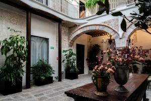 a room with a table with vases of flowers on it at HOTEL BOUTIQUE CASONA 65 in Puebla