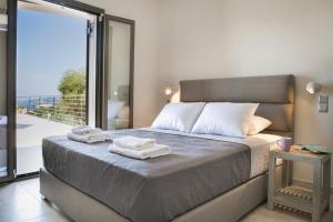a bedroom with a bed with towels on it at Escape Villa Kefalonia in Lourdhata