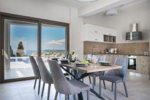 a kitchen and dining room with a table and chairs at Escape Villa Kefalonia in Lourdhata