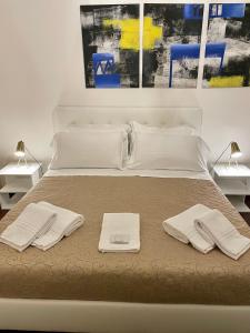 a bed with two towels and two lamps on it at Dimora Montecchi in Verona