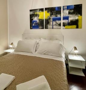 a bedroom with a large bed with three paintings on the wall at Dimora Montecchi in Verona