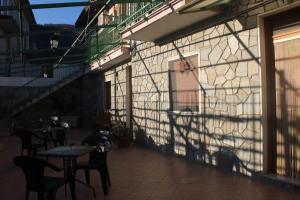 a shadow on the side of a building with tables and chairs at Bed & Breakfast Il Sentiero in Agerola