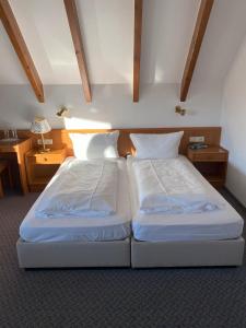 two twin beds in a room with at Hotel Faller in Breitnau