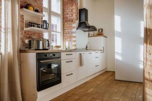 a kitchen with white cabinets and a black oven at PunaneLoss - Avar korter Viljandi südames in Viljandi
