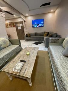 Sala de estar con 2 sofás y mesa en Résidence les Jardin d Anass Aéroport Marrakech, en Marrakech