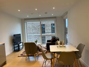 a living room with a table and chairs at Large 2 Bed Apartment London Close to Lewisham Hospital - Perfect for Long Stay in London
