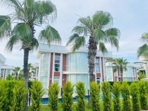 un bâtiment avec des palmiers en face de celui-ci dans l'établissement VillaVictoriaBelek, à Belek