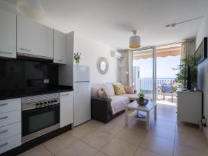 a kitchen and living room with a couch and a table at Incredible Sunsets in Puerto Rico de Gran Canaria