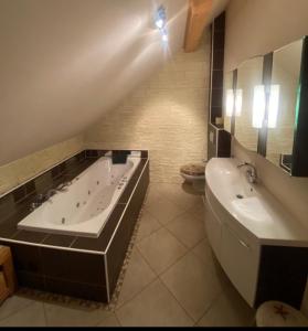 uma casa de banho com uma banheira, um lavatório e um WC. em Faakersee Seahouse mit Privat Strand -Only Sa-Sa em Faak am See