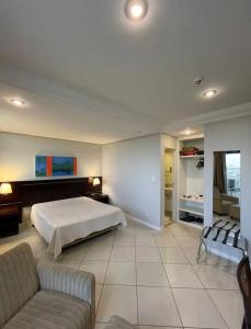 duża sypialnia z łóżkiem i kanapą w obiekcie Manaus hotéis millennium flat w mieście Manaus
