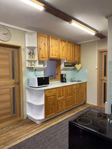 a kitchen with wooden cabinets and a microwave at Your getaway home in Jausa küla in Hiiumaa