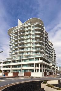 a large white building with a lot of windows at Oaks Glenelg Liberty Suites in Adelaide