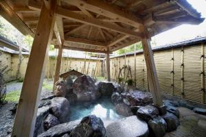 a pool of water under a pavilion with rocks at Wakatake in Tagami